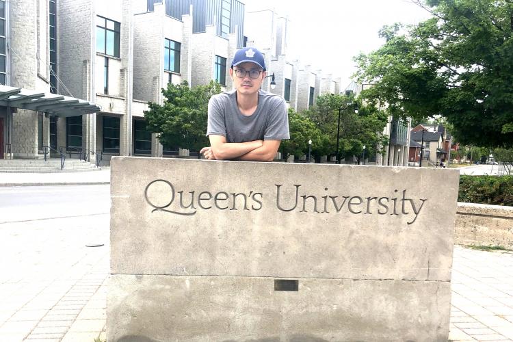 Zheng Chen in front of Queen's sign