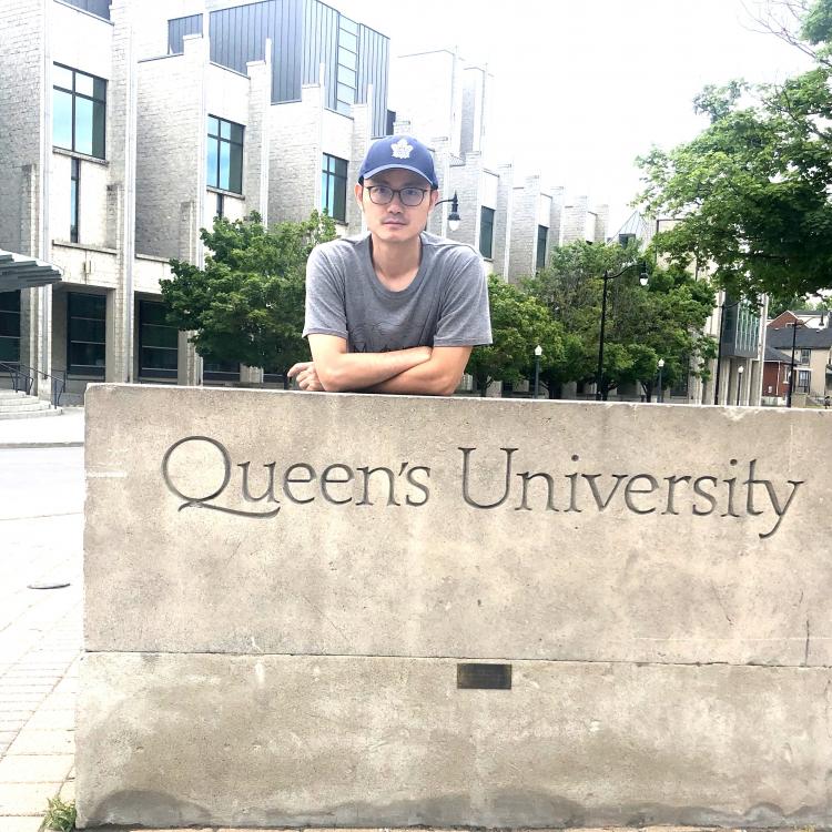 Zheng Chen in front of Queen's sign